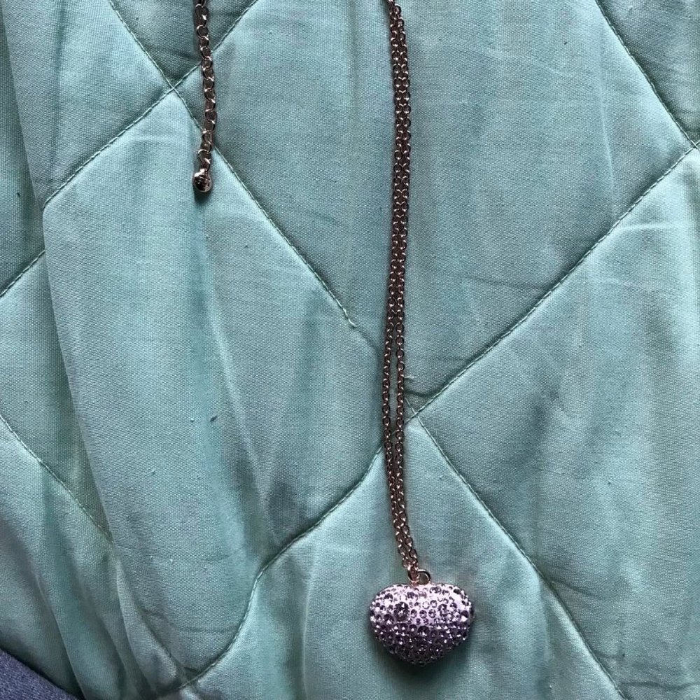 Rose metal necklace with shiny stones in heart shape.